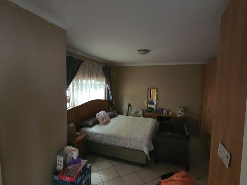 A standard bedroom featuring built-in cupboards and tiled flooring, offering a functional space with neutral wall tones.