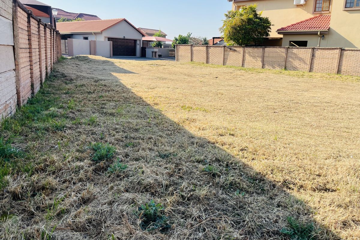 A vacant residential plot featuring established brick boundary walls, offering a clear space ready for development in a residential neighborhood.