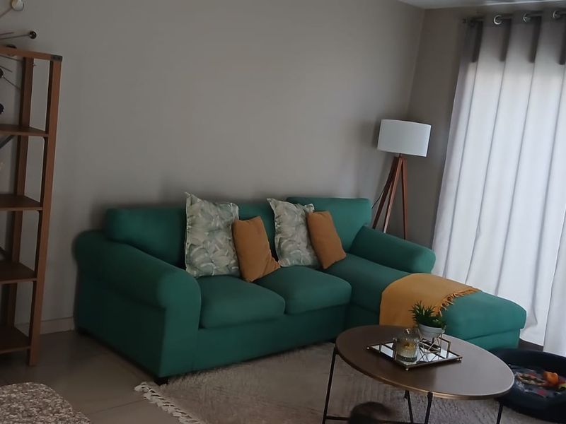 A comfortable living room featuring tiled flooring and large sliding glass doors that provide ample natural light.