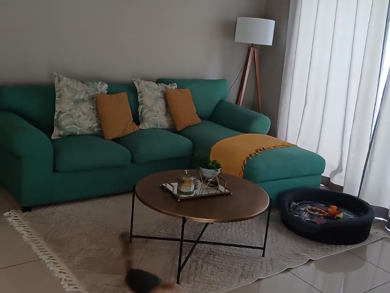A comfortable living room featuring neutral tiled flooring and large sliding glass doors that provide ample natural light.