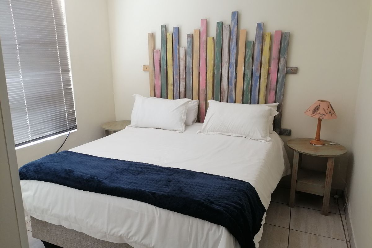 A functional bedroom featuring tiled flooring and venetian blinds, providing a neutral base for personalization.