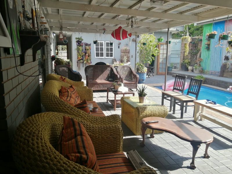 A covered outdoor patio area featuring paved flooring and direct access to an adjacent swimming pool, ideal for relaxed outdoor entertaining.