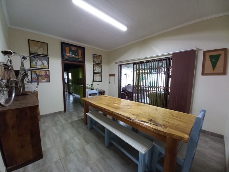 Dining room featuring tiled flooring and a sliding glass door with security gate, providing access to the outdoor area.