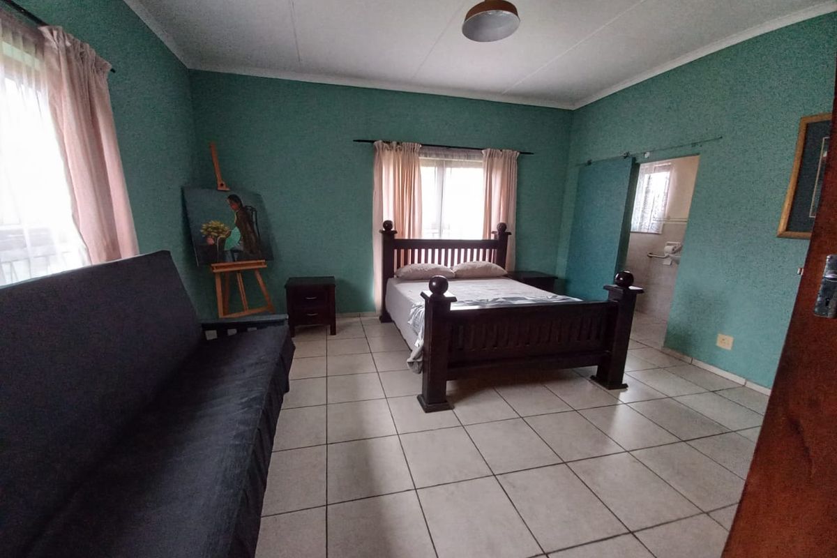 Spacious bedroom featuring tiled flooring and direct access to an en-suite bathroom area.