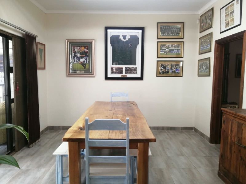 A dining room featuring neutral walls, tiled flooring, and a sliding glass door providing access to the outdoor area.