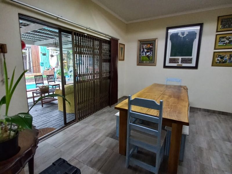 Dining room featuring tiled flooring and a large sliding glass door with security gate providing direct access to the outdoor patio area.