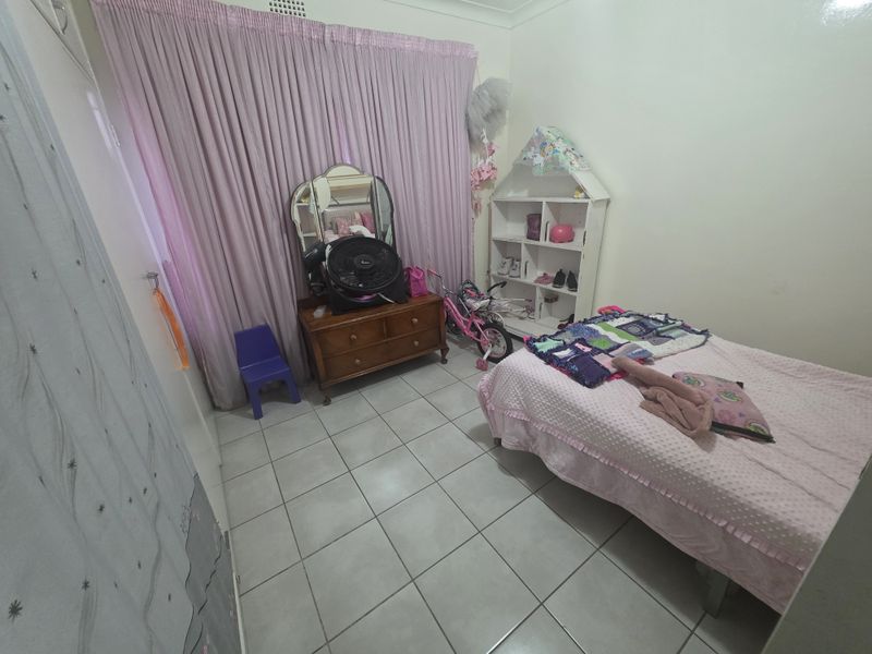A bedroom featuring tiled flooring and a built-in cupboard, currently utilized as a child's room.