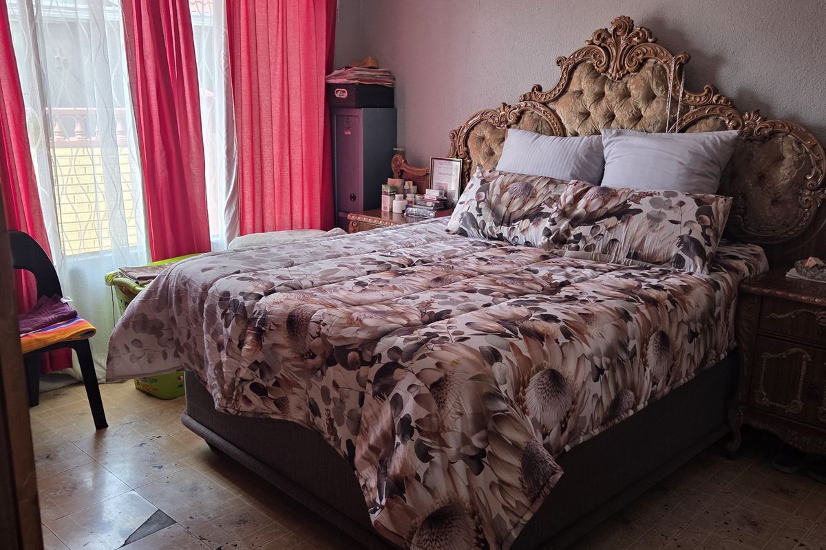 A bedroom featuring tiled flooring and coving, currently requiring cosmetic updates to the wall finishes and flooring to improve the overall aesthetic.