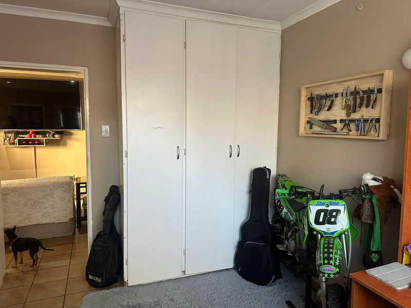Bedroom featuring a built-in wardrobe with white doors and decorative ceiling coving.