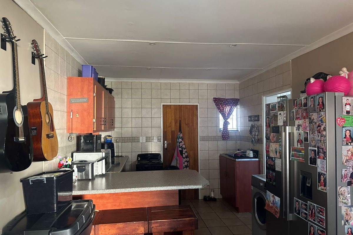 A functional kitchen featuring tiled walls, laminate countertops, built-in cabinetry, and tiled flooring, providing a practical workspace with a classic layout.