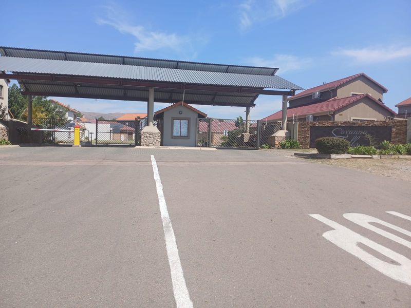 The entrance to the residential estate features a secure gatehouse, boom gate access, and a covered canopy structure.