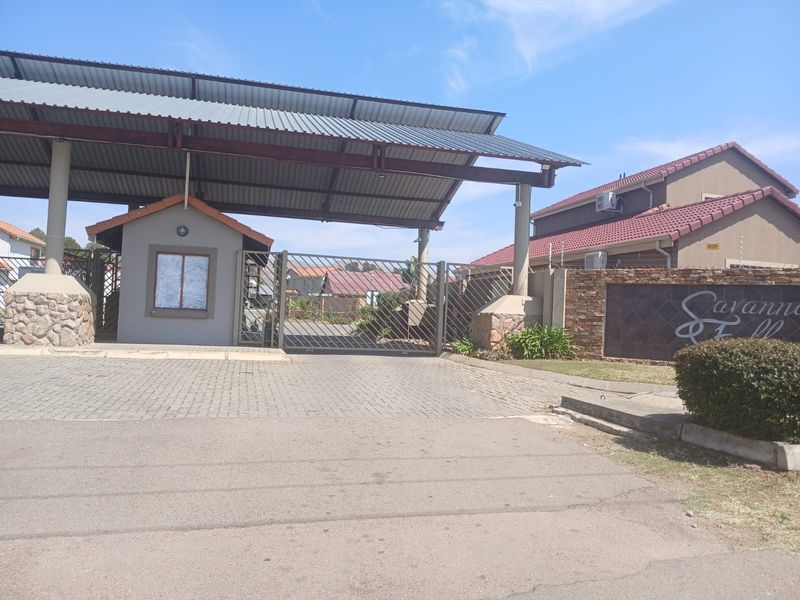 Main entrance gate and guard house for Savanna Falls residential estate, featuring paved driveway access and stone-clad perimeter walling.