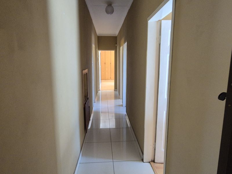 A functional hallway featuring tiled flooring and access to multiple rooms, providing a clean transition space within the home.