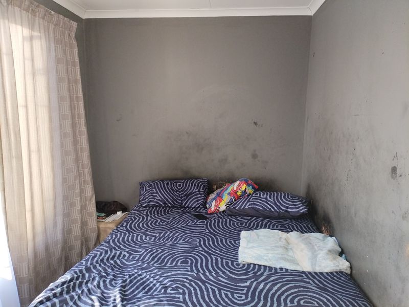 A bedroom featuring dark grey walls with significant soot or smoke staining, requiring professional cleaning or repainting to restore the space.