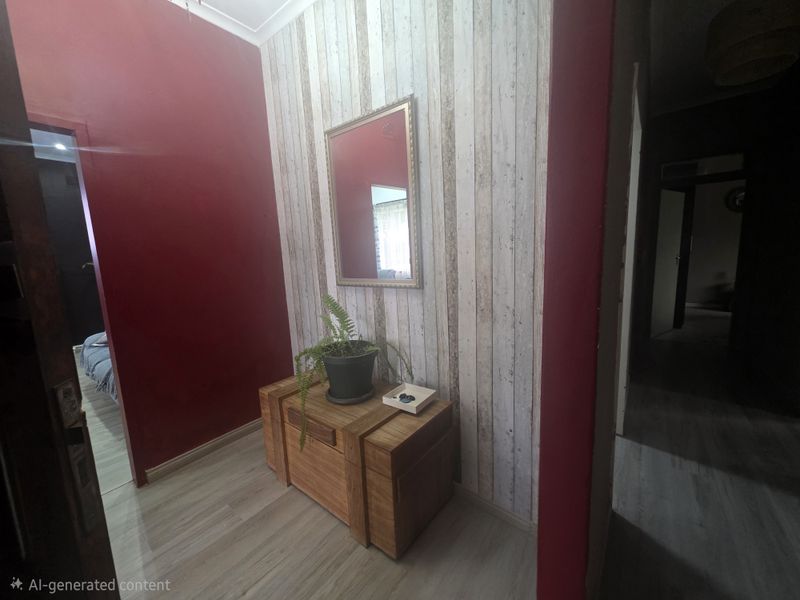 A hallway featuring laminate flooring and a decorative accent wall with a wall-mounted mirror.