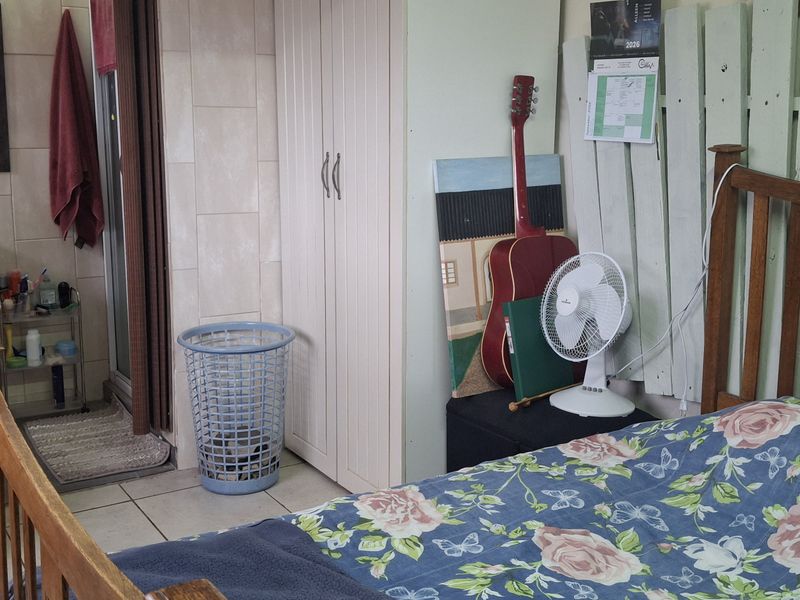 A bedroom featuring tiled flooring and a built-in wardrobe, with direct access to an en-suite bathroom.