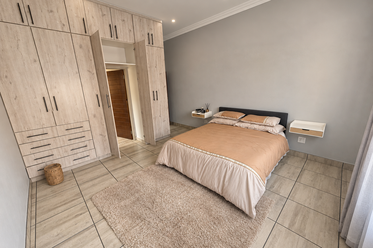 A well-maintained bedroom featuring extensive built-in cabinetry, floating bedside tables, and neutral tiled flooring with recessed lighting.
