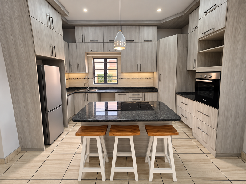 Modern kitchen featuring light wood-grain cabinetry, granite countertops, a central island with an integrated hob, and high-quality built-in appliances.
