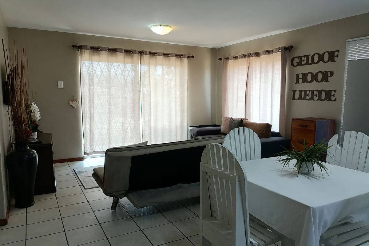 Open plan living and dining area featuring tiled flooring and large sliding glass doors providing natural light.
