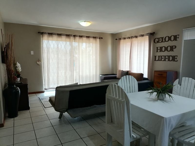 Open plan living and dining area featuring tiled flooring and large sliding glass doors providing natural light.