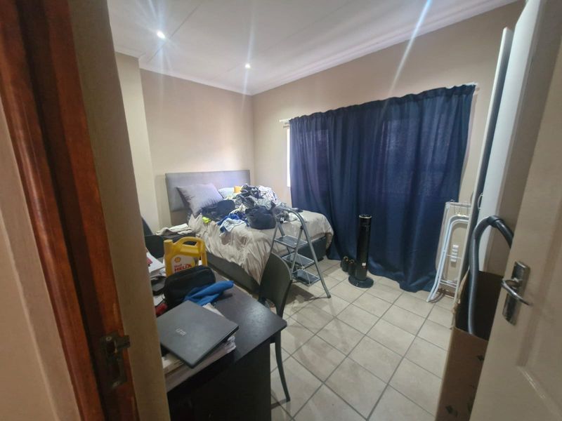A bedroom featuring tiled flooring and recessed ceiling lighting, offering a functional space for rest.