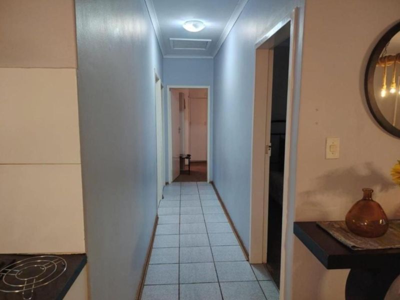 A functional hallway featuring tiled flooring and neutral wall finishes, providing access to multiple rooms within the home.