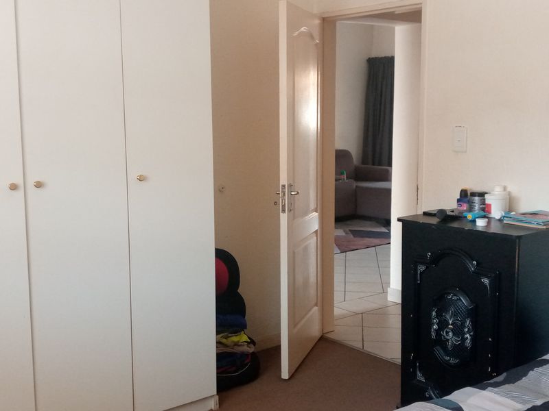 Bedroom featuring built-in wardrobes and an internal door leading to an adjacent living area.