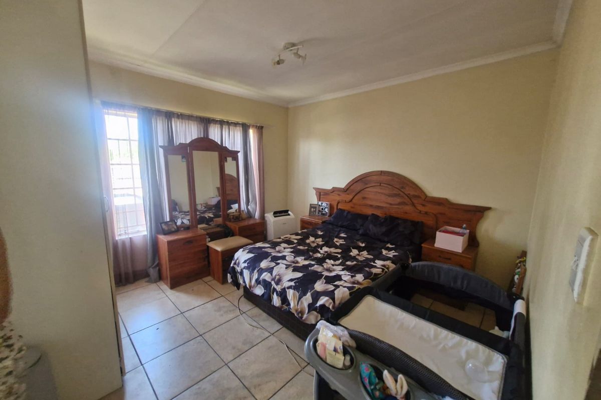 A standard bedroom featuring tiled flooring and a built-in cupboard, offering a functional space with neutral wall finishes.