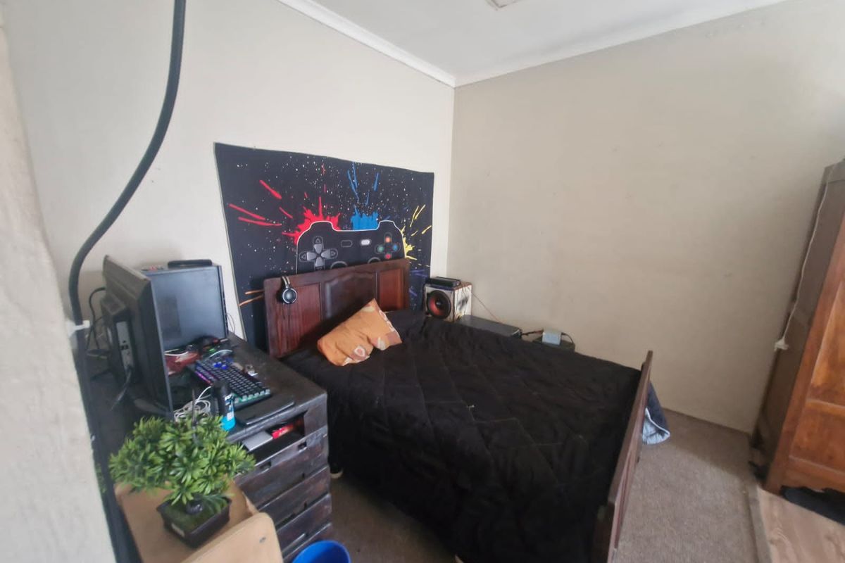 A functional bedroom featuring neutral wall finishes and carpeted flooring, providing a comfortable space for rest.