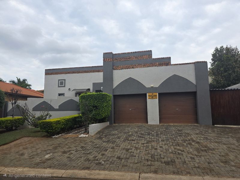 Front elevation of a residential property featuring a double garage with roller shutter doors and a paved driveway.
