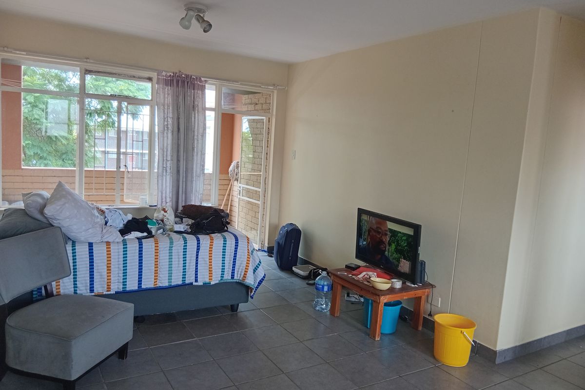 A bedroom featuring tiled flooring and a large sliding glass door providing access to an outdoor area.