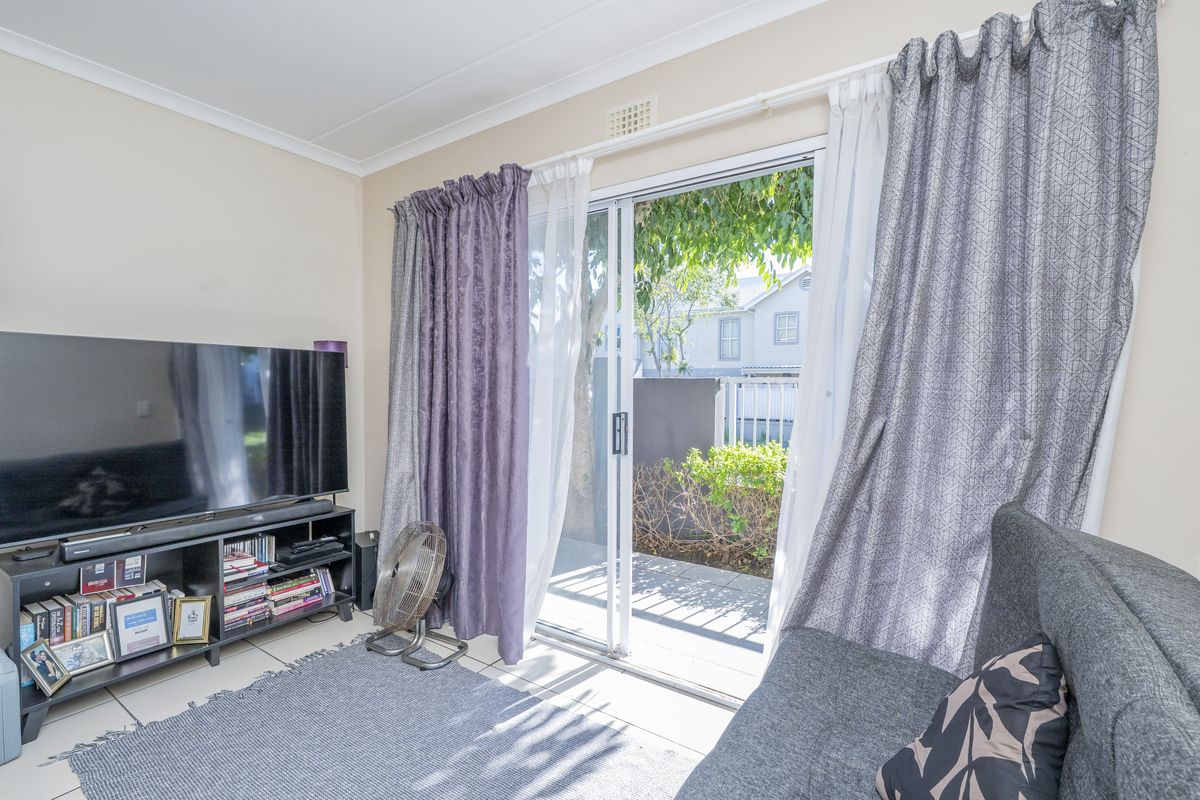 Living room featuring tiled flooring and a sliding glass door providing direct access to an outdoor patio area.