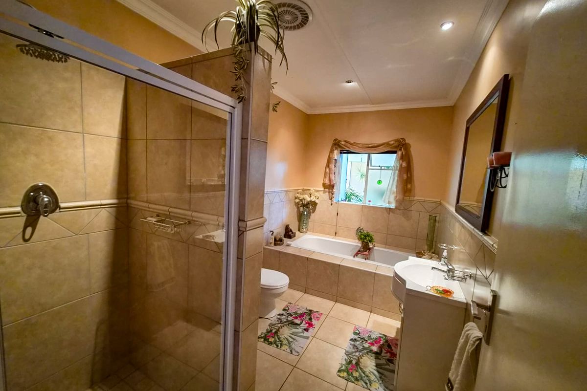 A functional bathroom featuring a separate shower enclosure, built-in bathtub, pedestal basin, and toilet with neutral tiled finishes throughout.