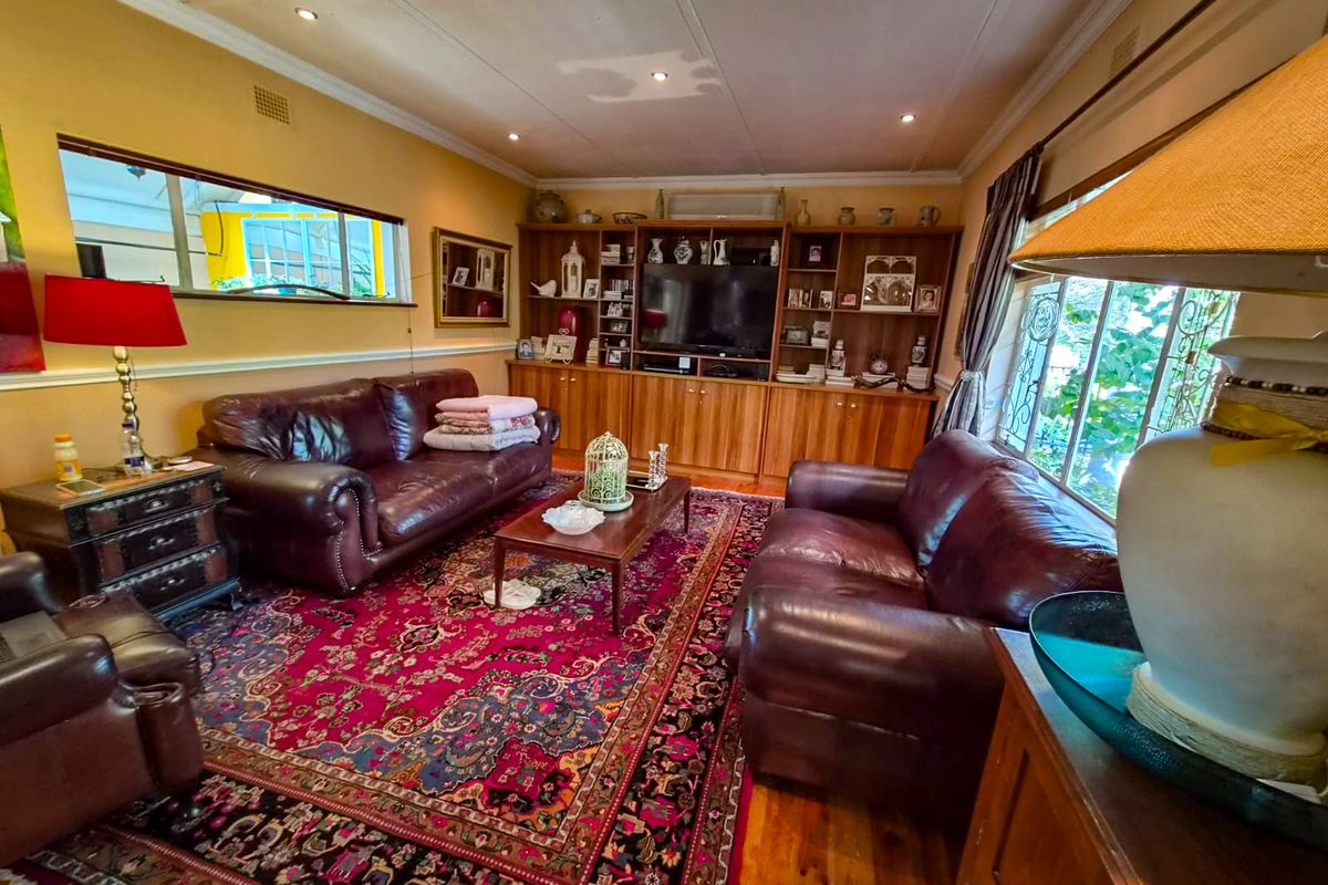 A traditional living room featuring built-in wooden cabinetry, hardwood flooring, and recessed lighting, offering a warm and functional space.
