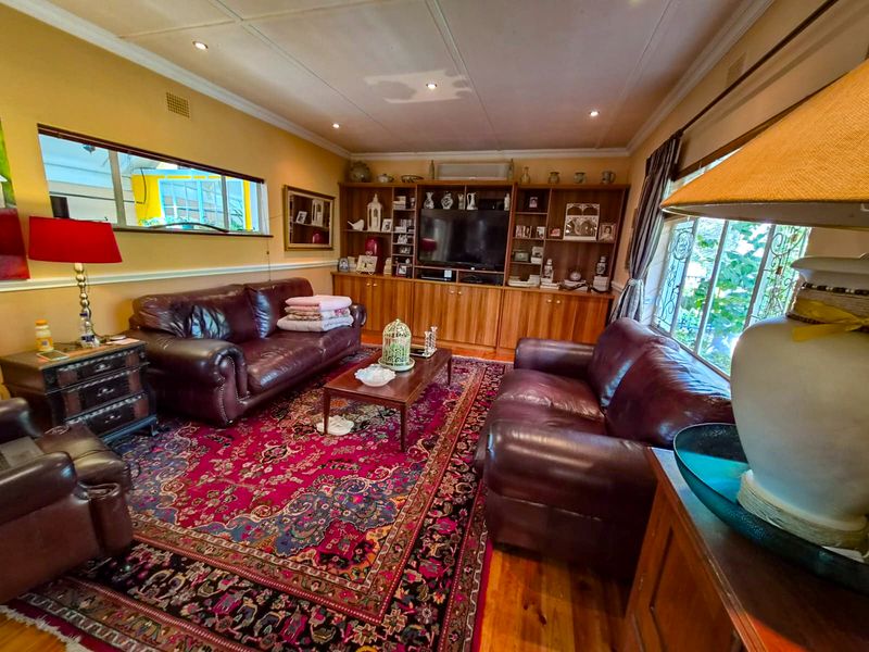 A traditional living room featuring built-in wooden cabinetry, hardwood flooring, and recessed lighting, offering a warm and functional space.