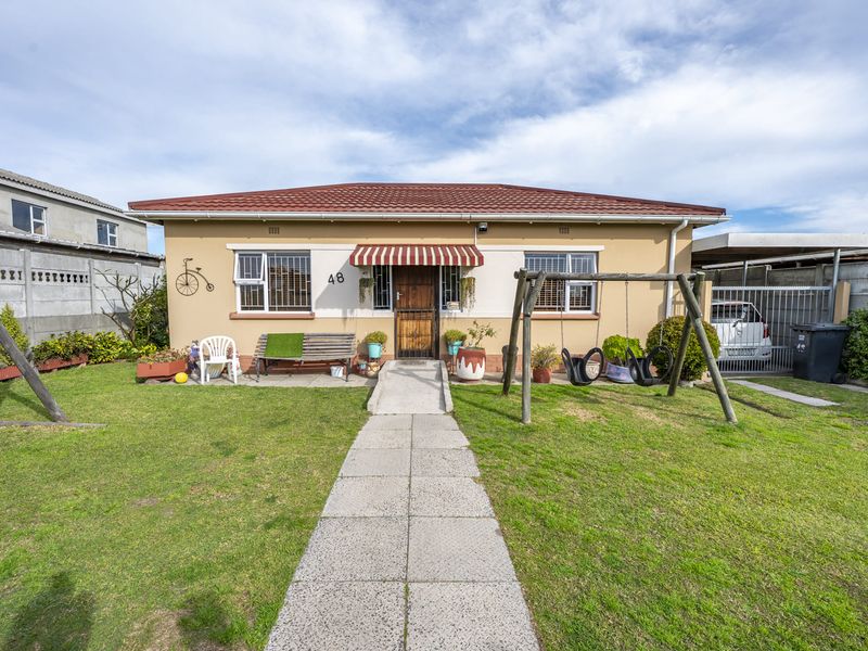 Front elevation of a single-story house featuring a tiled roof, concrete walkway, and a ramp leading to the entrance.