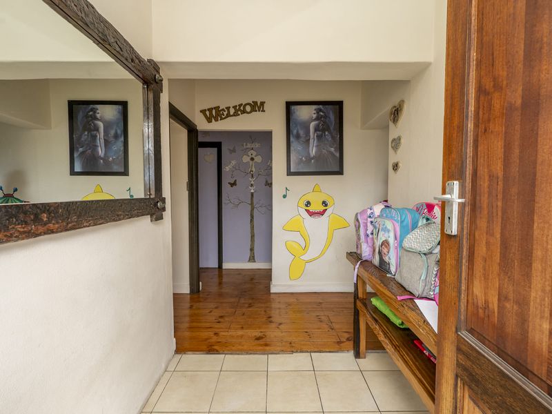 Entrance hallway featuring a mix of timber and tiled flooring, providing access to the interior living spaces of the home.