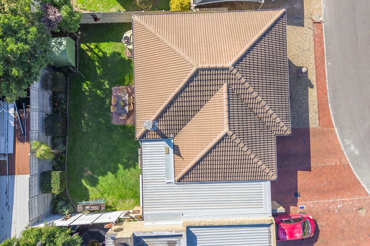 Aerial view of the property showing the roof structure, rear garden, and brick driveway access.