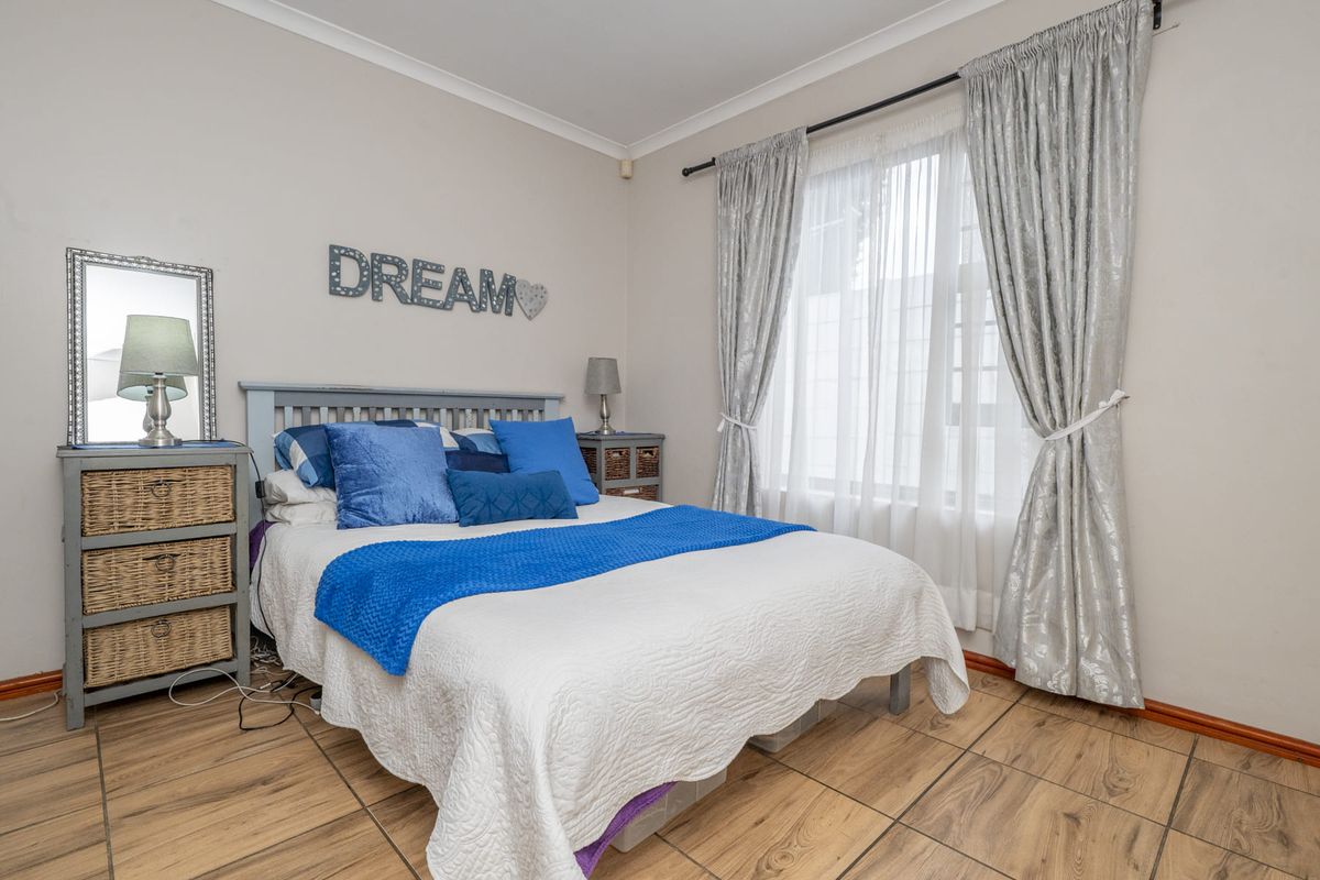 A well-lit bedroom featuring tiled flooring and neutral wall finishes, providing a comfortable and functional living space.