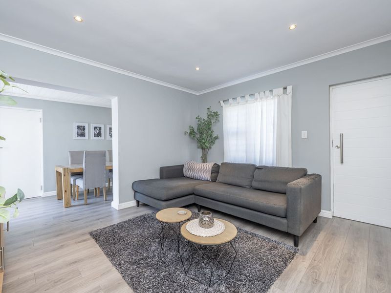 Bright open-plan living and dining area featuring modern laminate flooring, neutral wall tones, and recessed downlighting throughout the space.