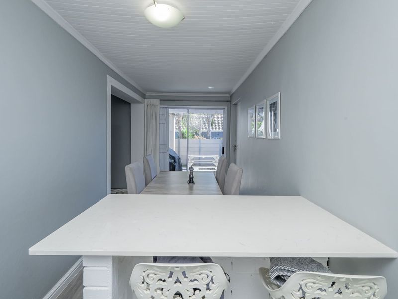 Open plan dining area featuring a breakfast bar, tongue and groove ceiling, and sliding glass doors leading to an outdoor patio space.