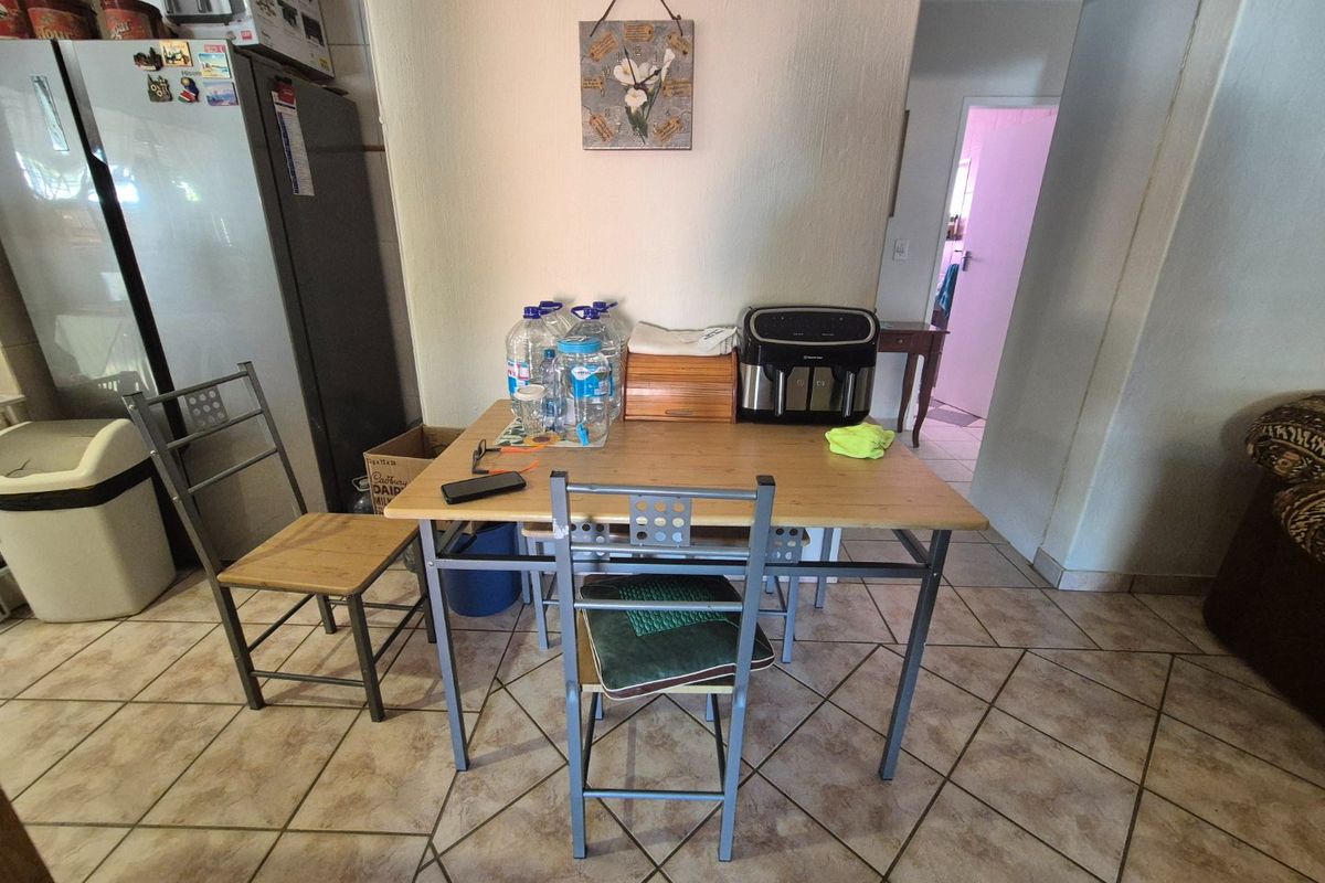 A functional kitchen area featuring tiled flooring and a neutral wall finish, providing a practical space for daily meal preparation and dining.