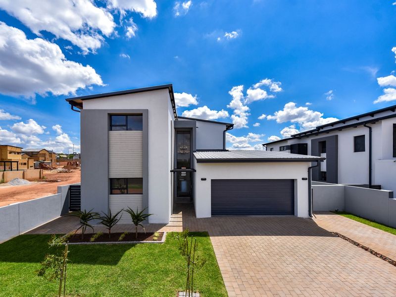 Modern double-storey residential home featuring a paved driveway, integrated double garage, and well-maintained front garden with contemporary architectural finishes.