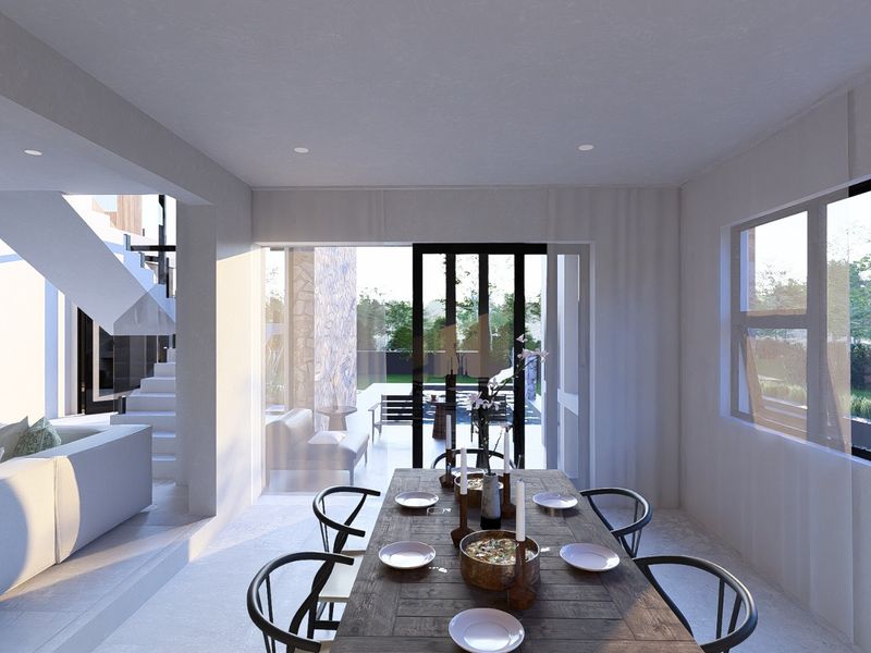 Modern open-plan dining area featuring a staircase and large sliding glass doors that provide seamless access to the outdoor patio and garden.