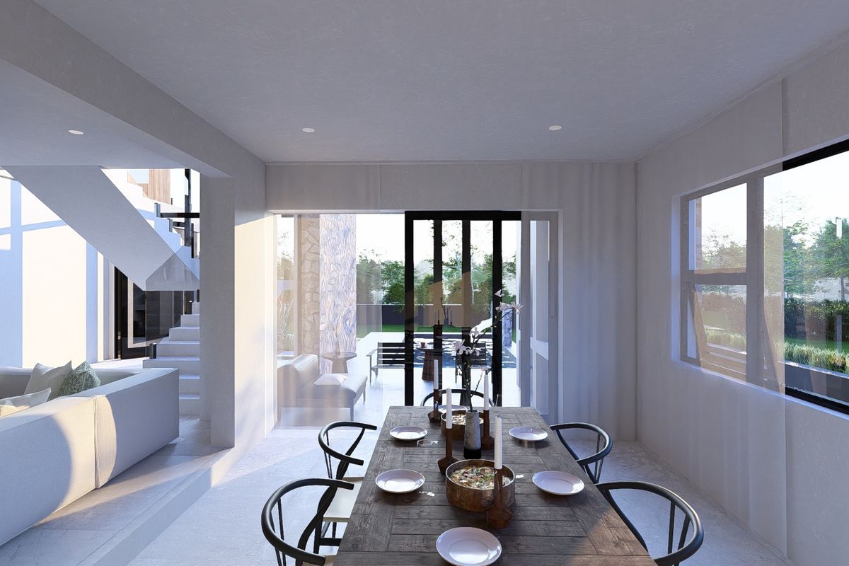 Modern open-plan dining area featuring a staircase and large sliding glass doors that provide seamless access to the outdoor patio and garden.