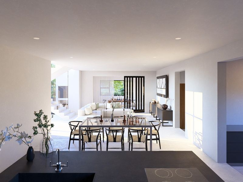 Modern open-plan living and dining area featuring a sleek kitchen island, recessed lighting, and contemporary architectural finishes.