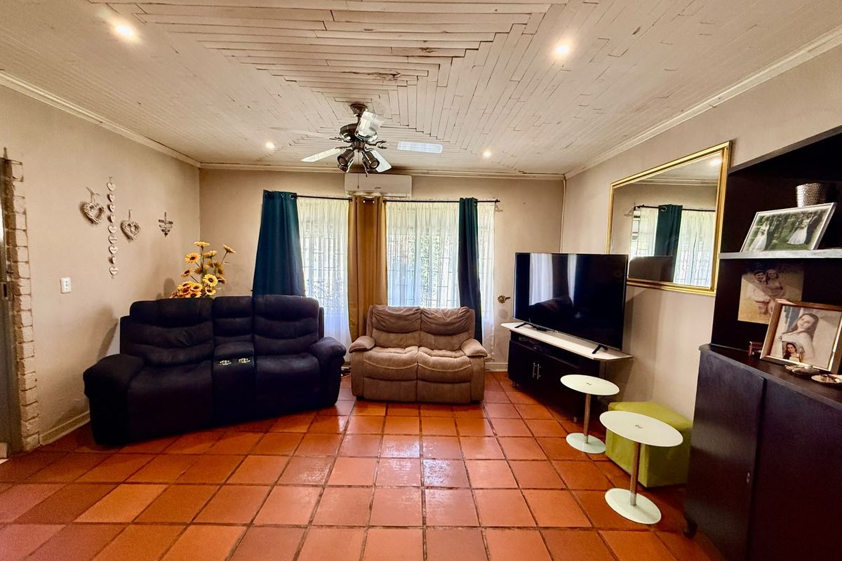 Living room featuring terracotta floor tiles, a timber plank ceiling with a ceiling fan, and a wall-mounted split-system air conditioner.