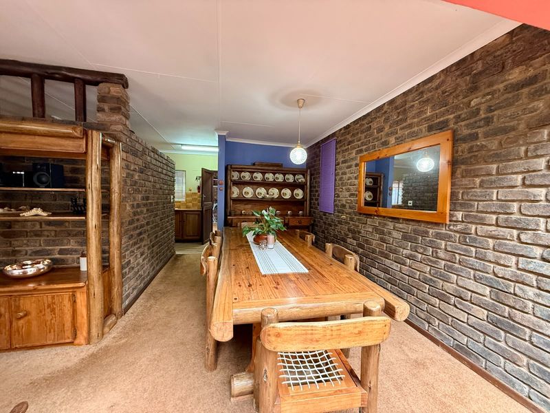 Dining room featuring exposed brick walls, built-in timber shelving, and pendant lighting, offering a rustic aesthetic with potential for modern updates.