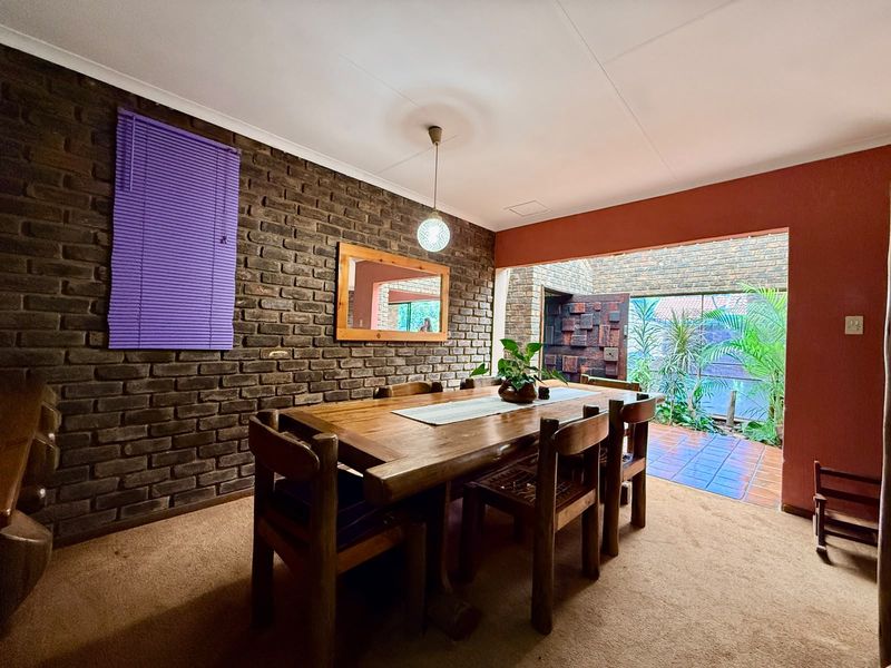 Dining room featuring an exposed brick wall, pendant lighting, and direct access to an outdoor patio area.