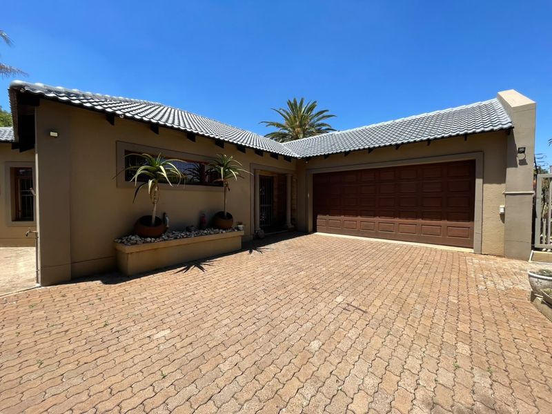 Front exterior view of the property featuring a paved driveway, a double garage with a sectional door, and a built-in planter box.